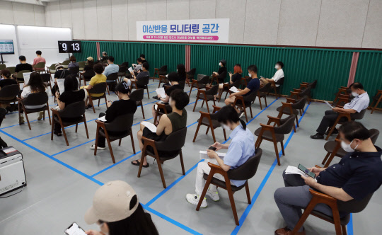 국내 코로나19 신규 확진자 수가 2천52명을 기록하며 이틀째 2천명대를 기록한 20일 오전 서울 동작구 제2예방접종센터가 마련된 동작구민체육센터에서 시민들이 백신 접종 뒤 이상반응을 살피기 위해 대기하고 있다.  연합뉴스